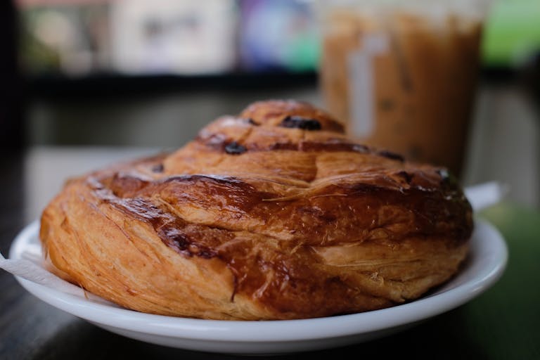 Appetizing close-up of a flaky pastry served on a plate with blurred background.