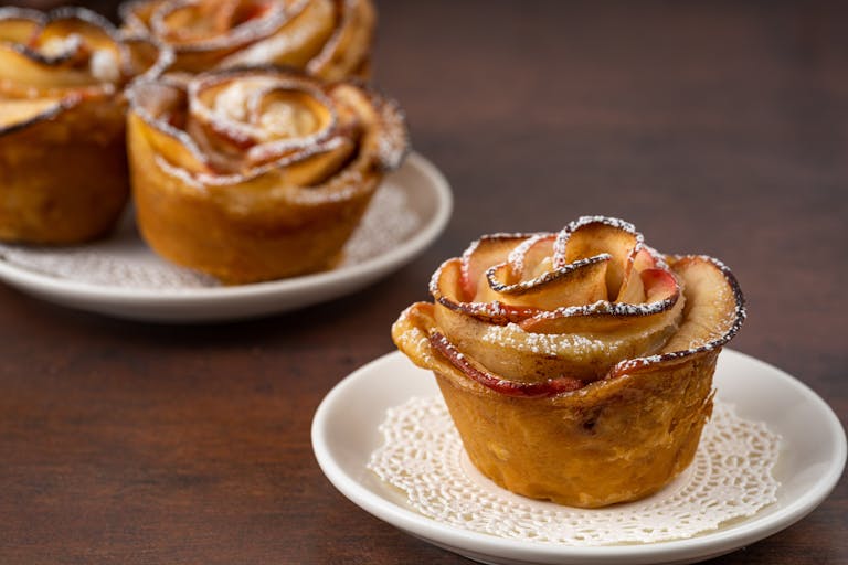 Apple rose pastries arranged elegantly on a plate, perfect for dessert lovers.
